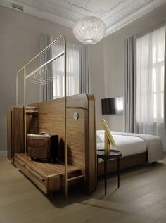 a room with a bed, chair and luggage on the floor