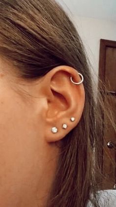 a woman's ear with three piercings on it, and one in the middle