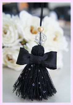 a black tasseled keychain with a beaded bow hanging from it