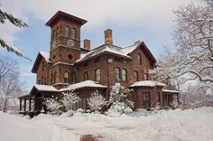 an old brick house with snow on the ground