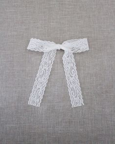 a white lace ribbon tied on top of a pillow