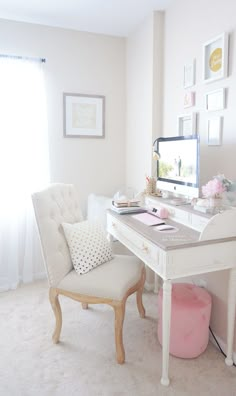 a white desk and chair in front of a window with pictures on the wall behind it