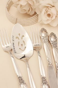 a set of five silver plated utensils with monogrammed initials on them