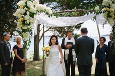 a bride and groom walking down the aisle at their outdoor wedding ceremony by the water