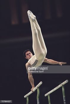 a young man is performing on the balance bars