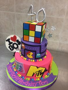 a colorful birthday cake with the number forty on it's top and an image of a rubik cube