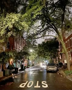 an empty street at night with lots of trees