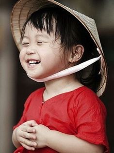 a young child wearing a straw hat and holding a toothbrush