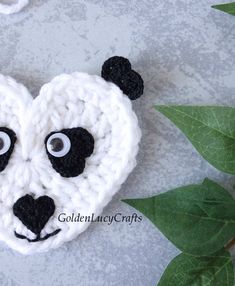 a crocheted panda bear brooch with eyes on it's head and nose