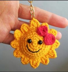 a crocheted sunflower keychain with a heart on it's face