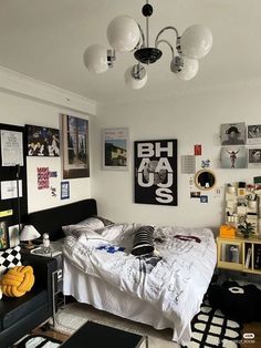 a bed room with a neatly made bed and lots of pictures on the wall above it