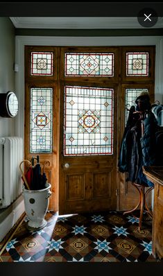 an entryway with stained glass windows and a coat rack on the door sill