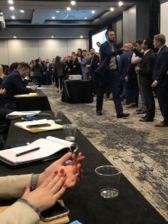 a group of people standing around a conference room