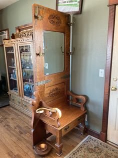 an antique wooden dressing table and mirror in a room with hardwood floors, green walls and wood trimmings