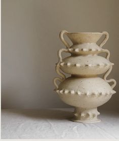 three white vases stacked on top of each other