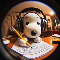 a dog with headphones sitting on top of a desk next to a pencil and paper