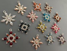 six snowflakes are shown in different colors and sizes on a gray surface