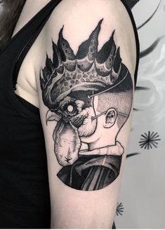 a woman's arm with a black and white tattoo design on the left shoulder