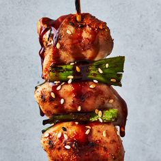 chicken and asparagus on skewers covered in bbq sauce with sesame seeds