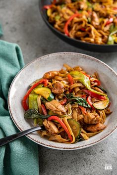 two bowls filled with stir fry and vegetables