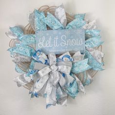 a wreath with snowflakes on it and a sign that says let it snow