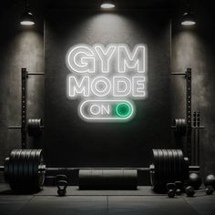 a gym room with neon sign and barbells