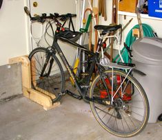 a bicycle parked next to a trash can in a garage