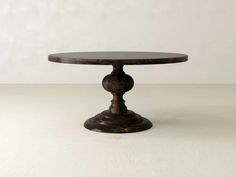 a round wooden table sitting on top of a white floor