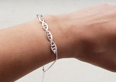 A simple, but versatile bracelet features a DNA Helix connector in silver plated metal. -7 inches long with 1 inch extender -Your choice of silver or gold plated bracelet -Lobster clasp for closure -One size should fit all If you need a specific size, I can adjust/customize. Makes a great gift for a Chemistry teacher, student, Lab scientist, biology field. Can't find what you are looking for or have a question? Message us and we will see what we can do! We love to customize and love a good chall Dna Bracelet, Lab Scientist, Dna Helix, Biology Teacher, Chemistry Teacher, Gift Bracelet, Teacher Student, Student Gift, Gold Plated Bracelets