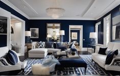 a living room with blue walls and white furniture in the center, along with an area rug on the floor