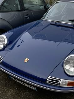 a blue sports car parked next to other cars