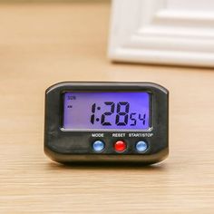 an alarm clock sitting on top of a wooden table