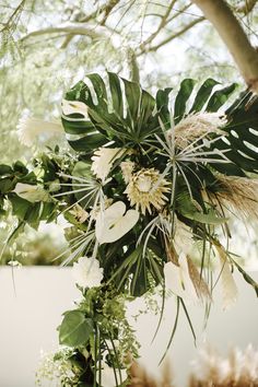 an arrangement of flowers and greenery in a vase