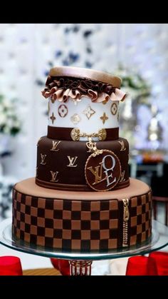 a three tiered cake with louis vuitton designs on the top and bottom