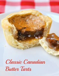 two small pastries sitting on top of a white plate with a red and white checkered tablecloth