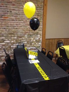 a table with some black and yellow balloons