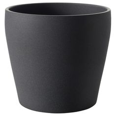 a black cup sitting on top of a white table