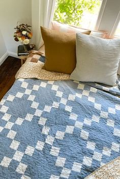 a blue and white quilt sitting on top of a bed