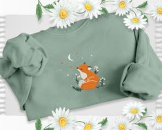 Embroidered Fox With Flowers Sweatshirt, Dreamy Moon Night Fox Design Aesthetic Sweater, Daisy Flower Fox Jumper, Minimalist Nature Clothing Take advantage of our current limited-time offer: a generous 70% discount on our entire stock. Don't let this opportunity slip away to gift your loved ones something special. Your thoughtful gestures will undoubtedly create lasting memories for them. Our company specializes in delivering top-quality personalization and customization services for clothing pr Fox Minimalist, Fox With Flowers, Nature Clothing, Thoughtful Gestures, Art Sweatshirt, Aesthetic Sweaters, Forest Fox, Moon Night, Fox Design