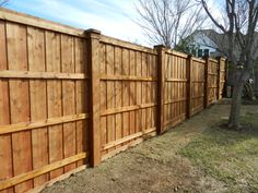 a wooden fence in front of a tree