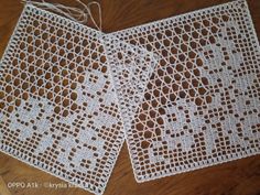 two white crocheted doily sitting on top of a wooden table next to each other