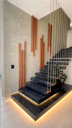 an elegant staircase with black marble steps and wooden handrails in a modern home