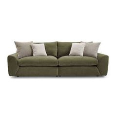 a green couch with four pillows on top of it and two white pillows on the back