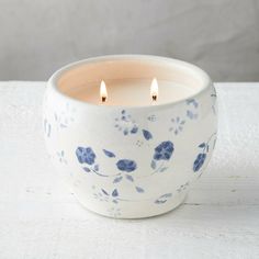 a white candle with blue flowers on it