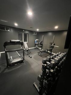 an empty gym room with equipment in the center and lights on above it, all lit up