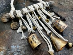 an assortment of bells and other items on a stone surface, including rope with brass bell caps