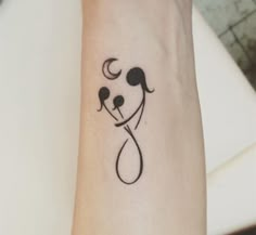 a small tattoo on the wrist of a person with a dog's head and tail