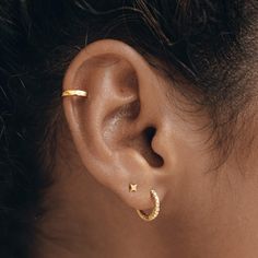 a woman's ear is shown with two small stars on the side of it