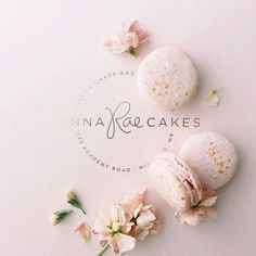 three macaroons sitting next to each other on a white surface with flowers around them