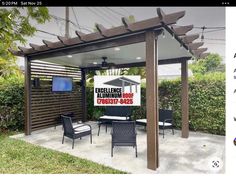 an outdoor living area with chairs and a television on the wall in front of it